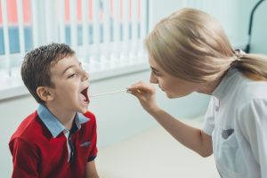 medic examineaza gatul unui baiat