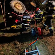Bărbat prin sub un tractor, la Mermești